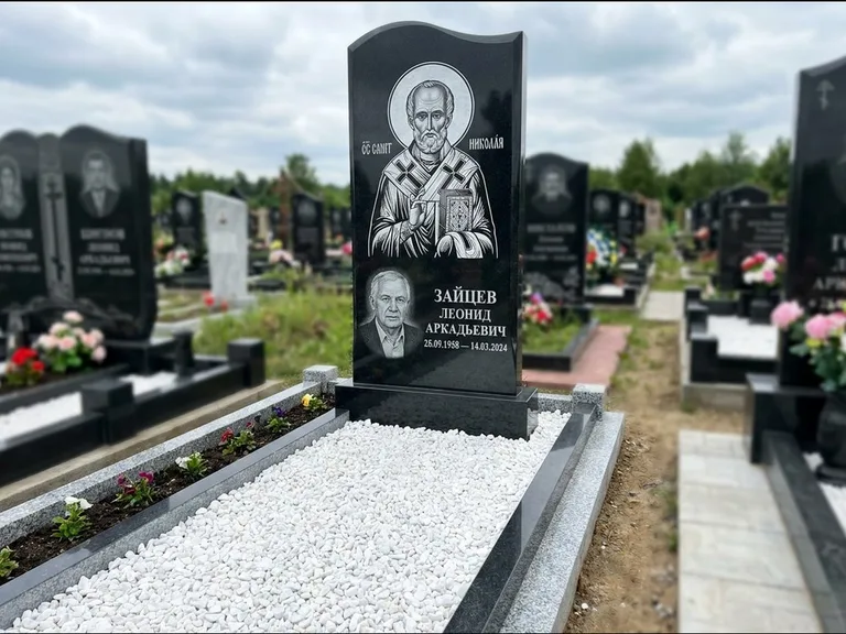 Памятник с гравировкой иконы: стела с крестообразным навершием — икона в резной рамке-киоте, газон без ограды, стриженая трава, работа «Раевская» в Альметьевске
