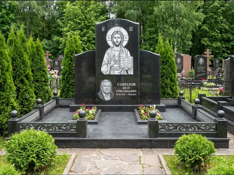 Памятник с гравировкой иконы: широкая горизонтальная лежачая плита-стела — икона в резной рамке-киоте, серая гравийная отсыпка с бордюром, работа «Богданова» в Альметьевске