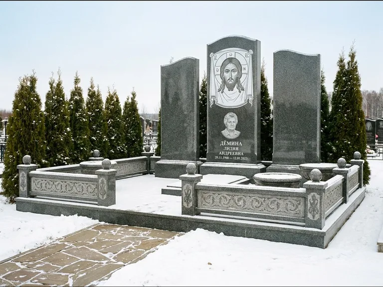 Памятник с гравировкой иконы: узкая вертикальная стела-пилон с ликом — икона в резной рамке-киоте, открытая лужайка без ограды, работа «Одинцов» в Альметьевске