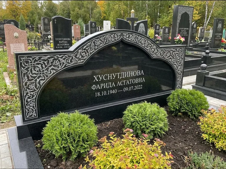Мусульманский памятник: вытянутая горизонтальная семейная стела с аркой — белая гравировка силуэта мечети с минаретами, участок с декоративными кустами, работа «Зарипова» в Альметьевске