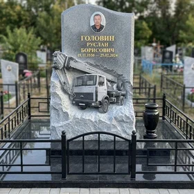 Гранитный памятник с барельефом автокрана и скальным краем